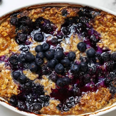 Delicious blueberry baked oatmeal served in a bowl, topped with fresh blueberries.