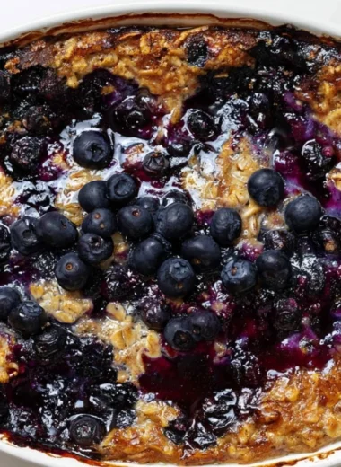 Delicious blueberry baked oatmeal served in a bowl, topped with fresh blueberries.