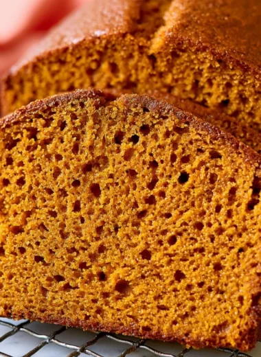 A slice of cozy healthy pumpkin bread on a rustic wooden table