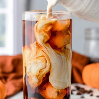 Cozy pumpkin spice cold brew served in a glass with autumn leaves