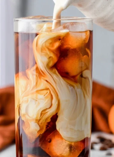 Cozy pumpkin spice cold brew served in a glass with autumn leaves