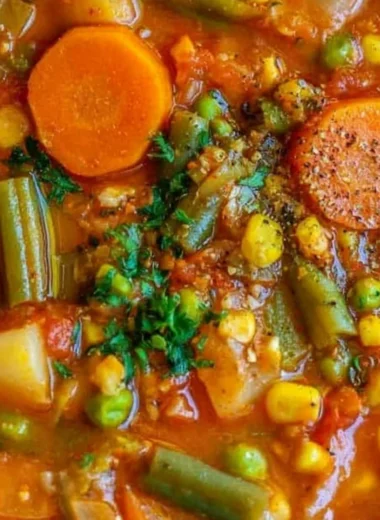 Bowl of cozy vegetable soup with fresh ingredients and herbs.