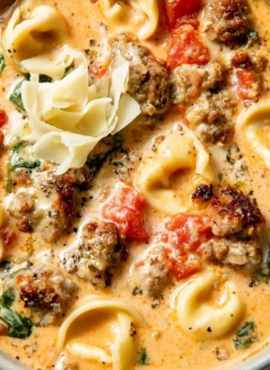 Bowl of creamy tortellini soup with fresh herbs and spices