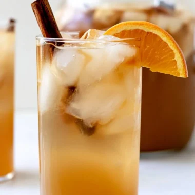 Delicious fall harvest punch in a decorative glass with autumn fruits.