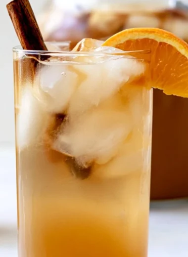 Delicious fall harvest punch in a decorative glass with autumn fruits.