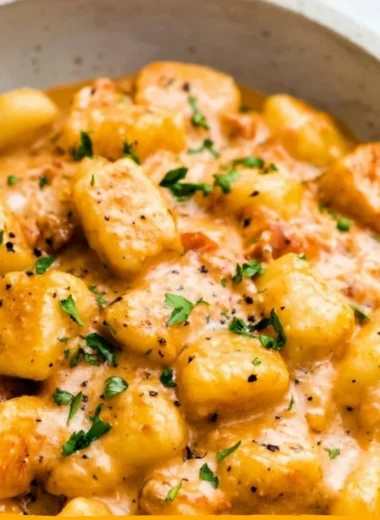 Plate of garlic butter gnocchi garnished with herbs and parmesan cheese