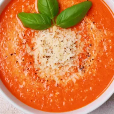 Bowl of high protein tomato soup garnished with herbs and spices
