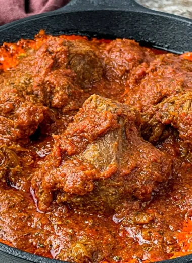Bowl of delicious Nigerian beef stew served with rice and plantains