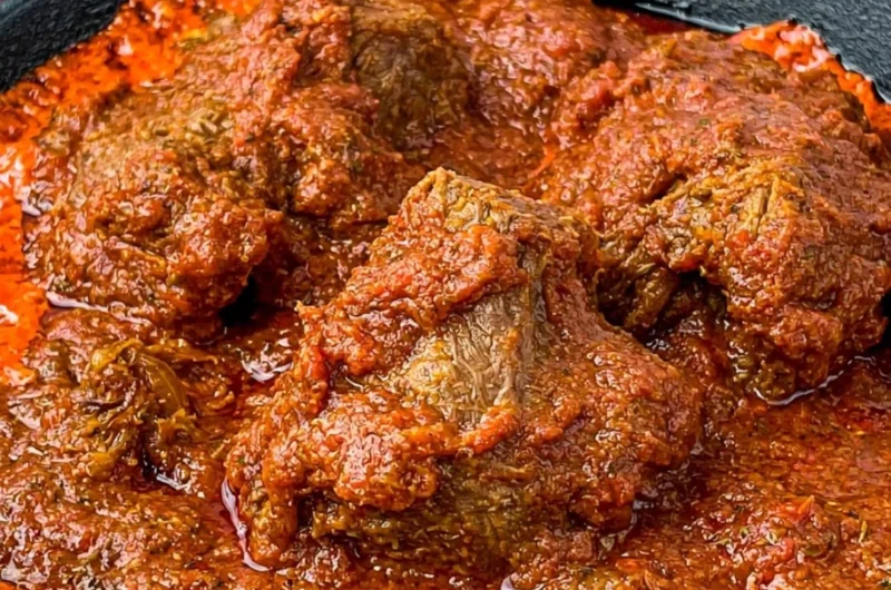 Bowl of delicious Nigerian beef stew served with rice and plantains