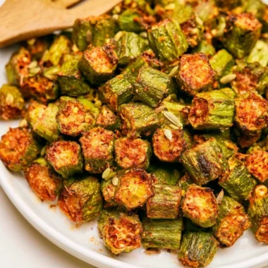 A plate of crispy, roasted okra garnished with herbs.