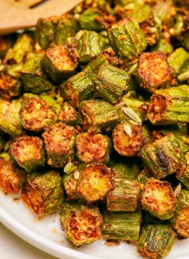 A plate of crispy, roasted okra garnished with herbs.