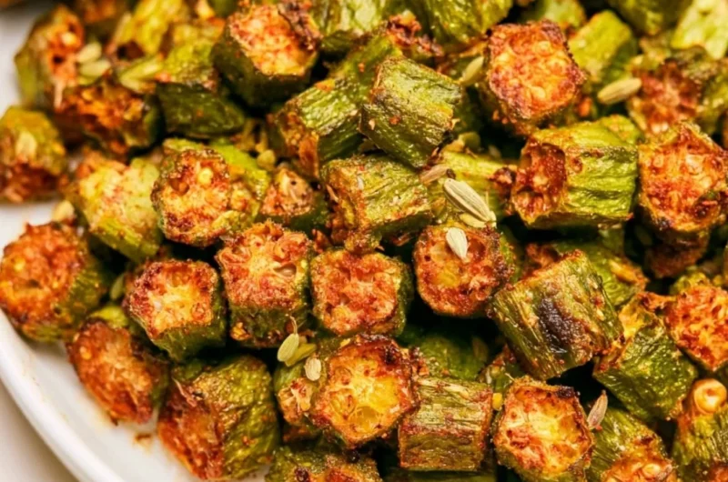A plate of crispy, roasted okra garnished with herbs.
