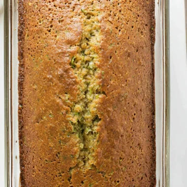 Loaf of freshly baked zucchini bread on a wooden cutting board