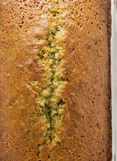 Loaf of freshly baked zucchini bread on a wooden cutting board