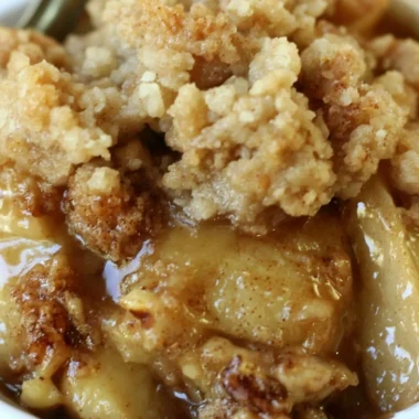 Delicious apple pear walnut crisp served in a bowl with a scoop of ice cream