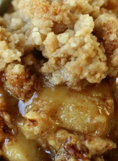 Delicious apple pear walnut crisp served in a bowl with a scoop of ice cream