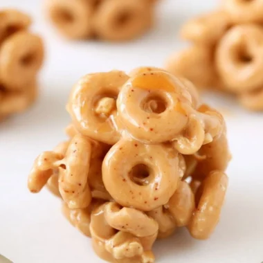 Delicious Peanut Butter Cereal Bites on a wooden table with a bowl of cereal.
