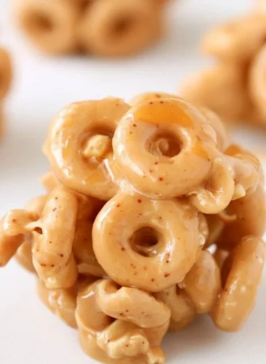 Delicious Peanut Butter Cereal Bites on a wooden table with a bowl of cereal.
