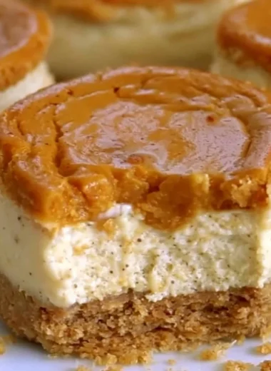 Cozy mini pumpkin cheesecakes topped with whipped cream and spices.