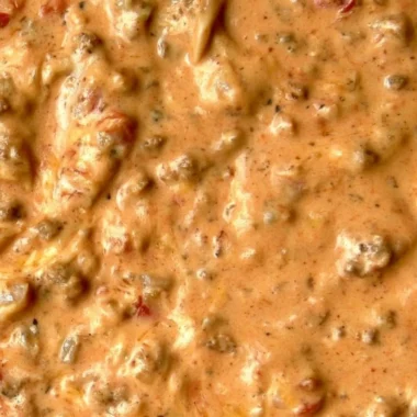 Bowl of delicious queso dip with tortilla chips on the side