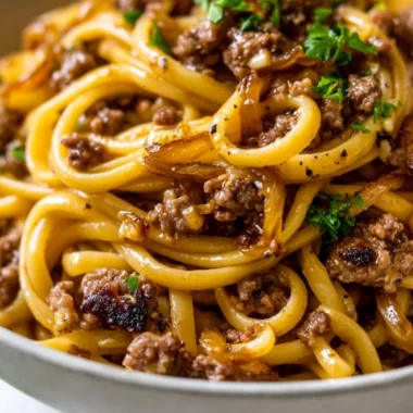 A delicious plate of Garlic Butter Beef Pasta garnished with parsley.