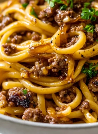 A delicious plate of Garlic Butter Beef Pasta garnished with parsley.