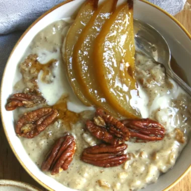 Delicious bowl of chai spiced pear porridge topped with fresh pears and spices
