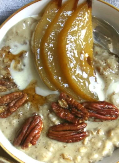 Delicious bowl of chai spiced pear porridge topped with fresh pears and spices