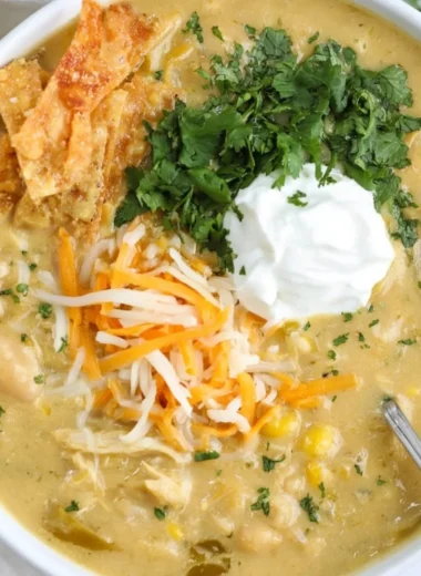 Bowl of easy green enchilada chicken soup topped with cilantro and lime