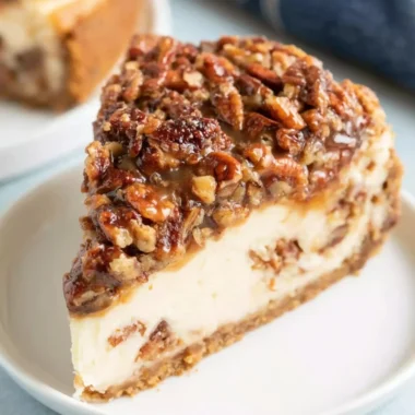 Delicious pecan pie cheesecake topped with caramel and pecans