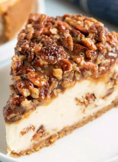 Delicious pecan pie cheesecake topped with caramel and pecans