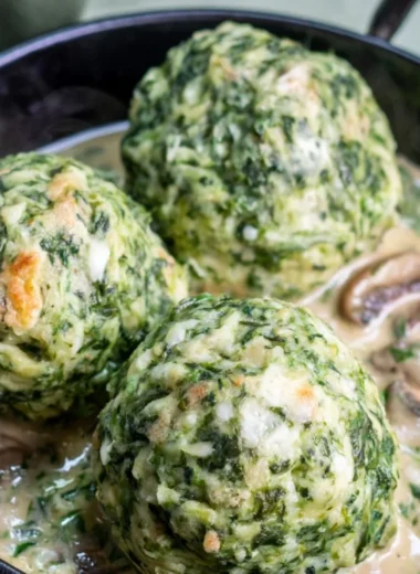 Plate of spinach dumplings served with creamy mushroom sauce