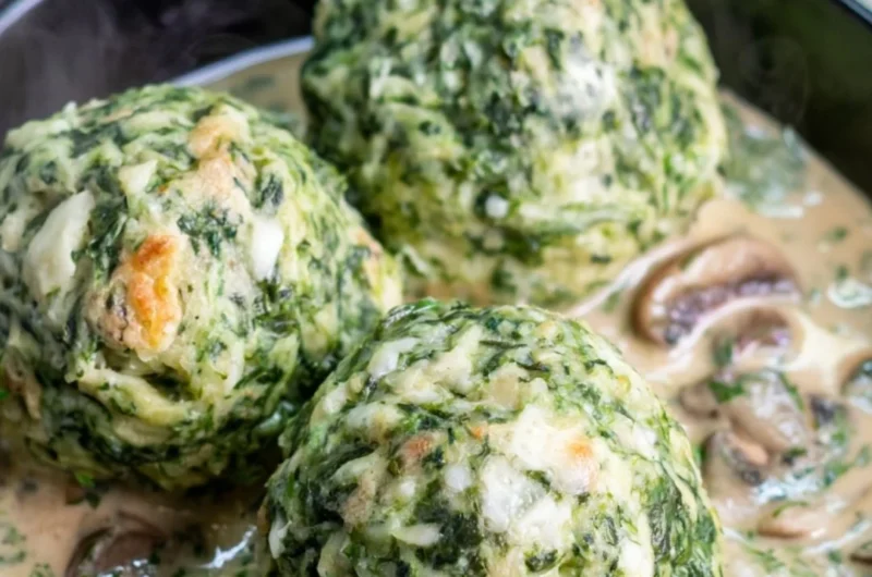 Plate of spinach dumplings served with creamy mushroom sauce